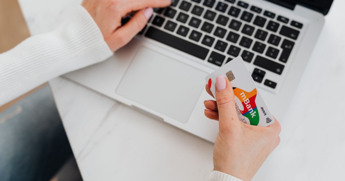Hands paying online with a credit card on a laptop