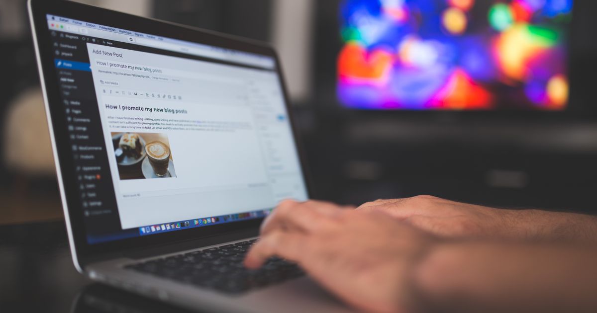 Hands typing on a laptop with a WordPress editor open